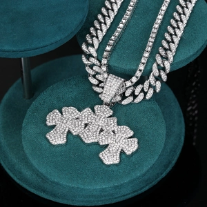 Dettaglio del pendente croce hip hop placcato argento con zirconi su espositore in velluto