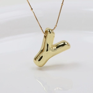Makro-Detail der goldenen 3D Bubble Buchstabe Y Kette mit poliertem Spiegelglanz