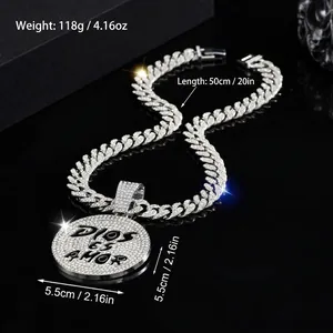 Silver iced-out Cuban chain with a round pendant engraved Dios Es Amor on black background