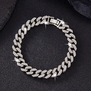 Close-up of 10mm double row rhinestone silver Cuban link bracelet on rock background