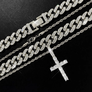 Close-up of iced-out cross pendant with silver Cuban link and rope chain necklace set
