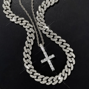 Close-up of silver iced-out Cuban chain and cross pendant necklace set for hip hop style