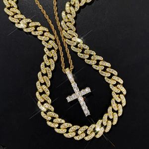 Close-up of gold Cuban link chain and iced-out cross pendant with sparkling crystals