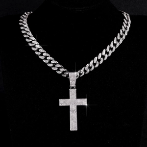 Iced out kruis hanger met zilveren Cubaanse schakelketting op een zwarte buste
