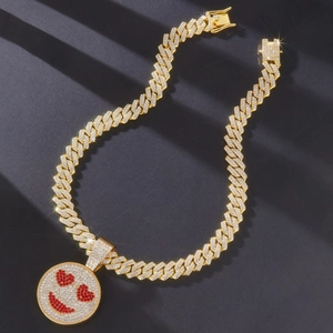 Close-up of golden Cuban link necklace with iced-out heart-eye smiley face pendant