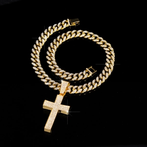 Detail van gouden Cubaanse schakelketting met sprankelende kruis hanger voor hiphop-stijl