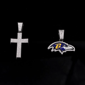 Macro-opname van iced-out kruis en Baltimore Ravens logo hangers met zirkonia steentjes
