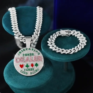 Macro shot of iced-out hip hop jewelry set with poker dealer pendant on green velvet