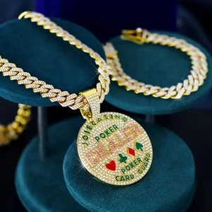Detail of iced out gold hip hop pendant with pink crystals on velvet jewelry stand