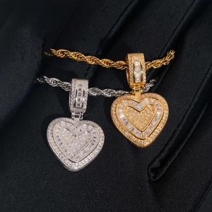 Macro detail of gold and silver iced out heart pendants with baguette-cut stones