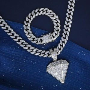 Close-up of iced out Cuban link chain set with sparkling diamond shape pendant