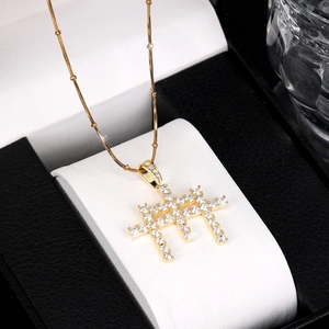 Détail du pendentif croix hip hop avec zircons micro-pavés sur une chaîne dorée fine