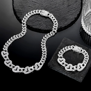 Détail de la chaîne cubaine et du bracelet argentés avec des maillons en cœur sertis