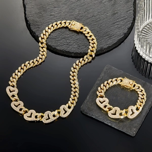 Détail du collier chaîne cubaine dorée avec maillons de cœur glacés sur pierre noire