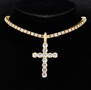 Close-up of gold plated tennis chain with a large iced out cross pendant on a black bust