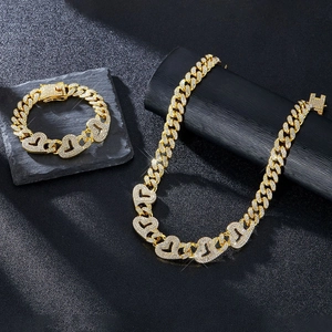 Détail d'un ensemble collier et bracelet cubain doré avec maillons cœur sertis de strass