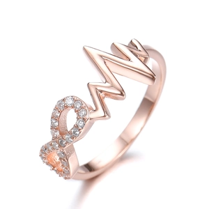 Macro detail of rose gold ring featuring infinity symbol and heartbeat design with zircons