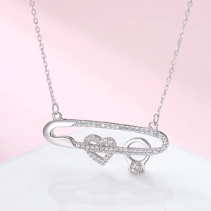 Vue macro du pendentif épingle de sûreté S925 avec cœur pavé et détail de bague diamant