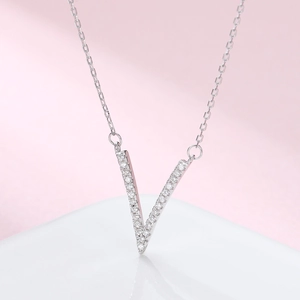 Close-up of a silver V-shaped pendant necklace with shimmering pave-set crystals
