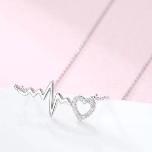 S925 sterling silver heartbeat necklace with sparkling zircon heart pendant on pink background