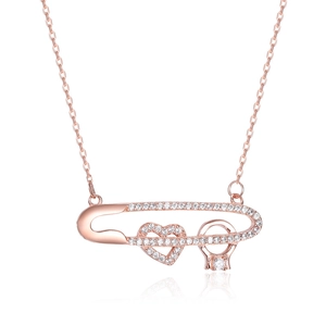 Collier épingle de nourrice or rose avec pendentifs cœur et bague sur fond blanc