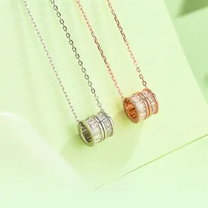 Detail of rose gold and silver cylinder pendants with micro-set square and round crystals