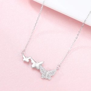 Minimalist S925 sterling silver butterfly necklace with zircon stones on a pink background