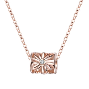 Macro shot of rose gold daisy cylinder pendant with hollow floral pattern and zircon