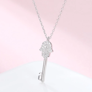 Macro shot of 925 silver Hamsa hand key pendant with sparkling zircon details