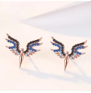 Dettaglio macro di orecchini ad ala in oro rosa con pavé di cristalli blu e neri sfumati