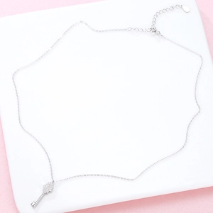 925 sterling silver key pendant necklace with sparkling pavé zircons on a pink background