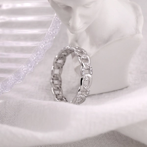 Detailed view of 925 sterling silver Cuban link ring with zircon stones on white fabric