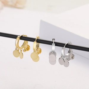 Detail of silver and gold layered hoop earrings with three small circular pendants