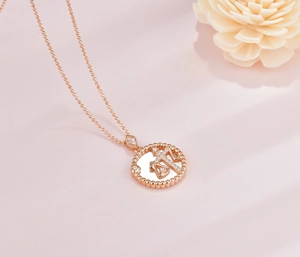 Detail of Rose Gold Libra zodiac pendant with iridescent white shell and crystal inlay