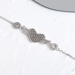 Vue macro du pendentif aile de cœur avec base alvéolée sur bracelet en argent sterling S925