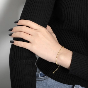 Delicate S925 sterling silver gold snake chain necklace worn on a black knit wrist