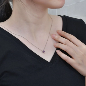 Close-up of S925 silver six-prong necklace featuring a round purple zircon pendant on a model