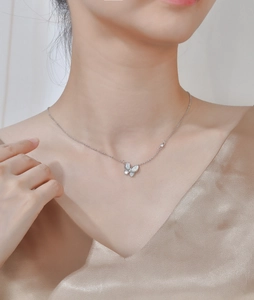 Collier papillon en argent 925 avec nacre blanche et cristaux porté par un mannequin