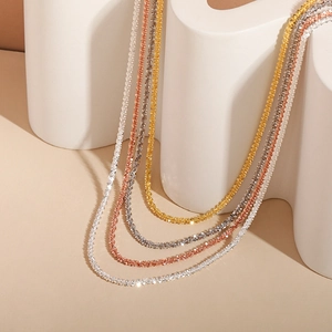 Detailed close-up of shiny gold silver and rose gold necklaces on art stand