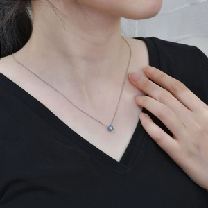 Macro shot of silver S925 necklace with a blue heart-shaped cubic zirconia gemstone