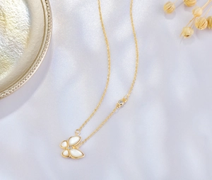 Détail d'un collier papillon en argent 925 avec nacre blanche et finition dorée