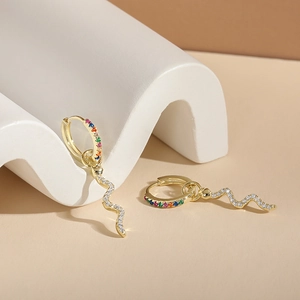 Détail de boucles d'oreilles serpent dorées avec gemmes arc-en-ciel et zircons blancs