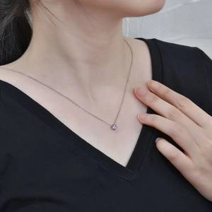Close-up of minimalist S925 silver necklace with round pink zircon pendant on a model