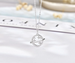 Macro view of S925 sterling silver Saturn pendant necklace with sparkling micro-pave zircons