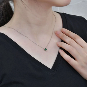 Detailed close-up of a S925 sterling silver necklace with a green zircon heart pendant