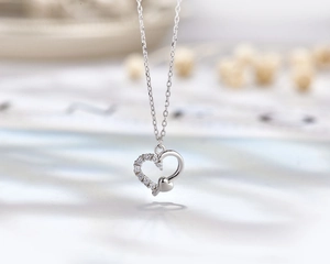 Macro view of S925 sterling silver heart necklace with asymmetric pavé set zircon stones