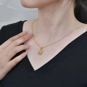Elegant gold Ping An Lock necklace with sparkling zircon pendant worn by a model