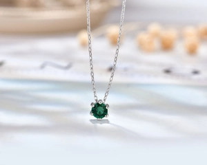 Macro shot of s925 silver six-prong necklace with a brilliant faceted green zircon stone