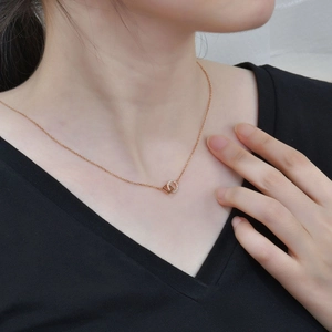 Collana geometrica in oro rosa con pendenti a cerchio e quadrato su una modella donna