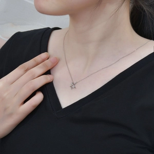 Elegant S925 sterling silver star pendant necklace on model with black V-neck top